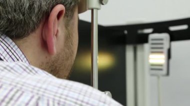 Dinamik fototerapi için bir cihaz. Optalmoloji kliniğindeki hasta, adam göz doktoru odasındaki dinamik fototerapi cihazına bakıyor, ışık tedavisi görüyor.