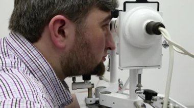 Göz hekimliği kliniğindeki hasta. İnsan sinnoflora bakar. Göz kaslarındaki dengesizliği teşhis etmek ve onları ortopedik yöntemlerle tedavi etmek, Strabismus tedavisinde kullanılır.