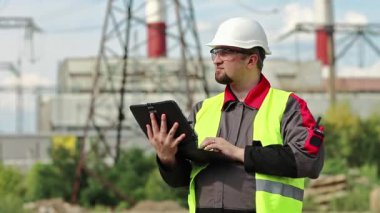Elektrik santralinde kişisel bilgisayarda çalışan bir elektrik mühendisi. Isı elektrik santralinde çalışan, mühendislik denetimi altında çalışan bir işçi. Elektrik santralinde bilgisayarı olan bir işçi
