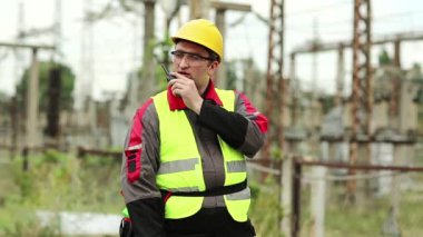 Elektrik santralinde taşınabilir radyo vericisi olan bir işçi. Isı santralindeki işçiler radyo istasyonuyla iletişim kuruyor.