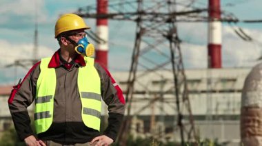 Elektrik santralinde kimyasal koruması olan bir işçi. Sanayi bölgesinde baret, gözlük ve solunum cihazı takan tamirci.