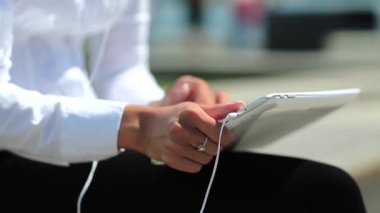 Kadın kapalı çekimde tablet bilgisayar kullanıyor. Fransız manikürlü kadın elleri tablet bilgisayarı tutuyor.