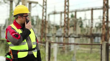 Elektrik santralinde taşınabilir radyo vericisi olan bir işçi. Isı santralindeki işçiler radyo istasyonu aracılığıyla iletişim kuruyor.