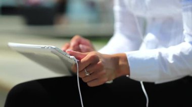 Kadın kapalı çekimde tablet bilgisayar kullanıyor. Fransız manikürlü kadın elleri tablet bilgisayarı tutuyor.