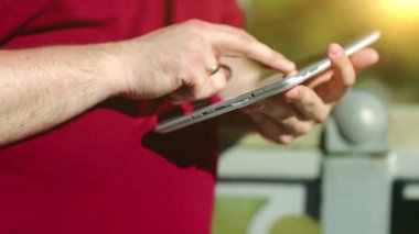 Adam tablet bilgisayar kullanıyor. İşadamı tablet bilgisayarla çalışır, kapatır, arka planda güzel bir güneş