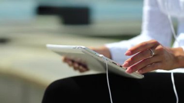 Kadın kapalı çekimde tablet bilgisayar kullanıyor. Fransız manikürlü kadın elleri tablet bilgisayarı tutuyor.