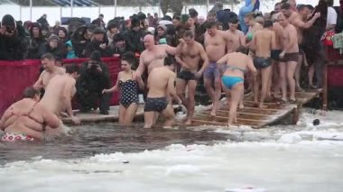 UKRAINE, KIEV, 19 Ocak 2018: İnsanlar Sviato-Pokrovskiy Katedrali yakınlarında Dinyeper Nehri 'nin buz gibi sularında yıkanır. Geleneksel kış, Kutsal Epifani Günü kutlamalarında soğuk suda yüzer.