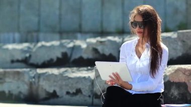 İş kadını tablet bilgisayarla konuşuyor. Beyaz tablet bilgisayarlı gözlüklü çekici bir kadın görüntülü sohbet yoluyla iletişim kuruyor.