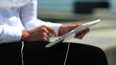 İş kadını kapalı çekimde tablet bilgisayar kullanıyor. Fransız manikürlü kadın elleri tablet bilgisayarı tutuyor.