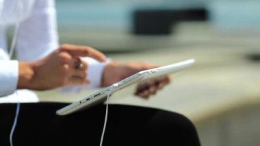 Kadın kapalı çekimde tablet bilgisayar kullanıyor. Fransız manikürlü kadın elleri tablet bilgisayarı tutuyor.