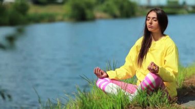 Güzel kız su kenarında meditasyon yapıyor. Meditasyon - bireyin zihni çalıştırdığı, eğittiği ya da bir bilinç biçimini tetiklediği uygulama