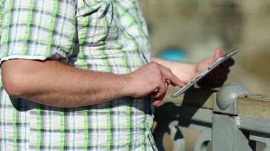 İşadamı tablet bilgisayarla çalışıyor, kapatın. Adam tablet bilgisayar kullanıyor, el tableti bilgisayarını tutuyor