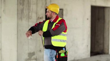 İnşaat alanında denetleyici personel. Proje alanında sarı şapkalı ustabaşı.