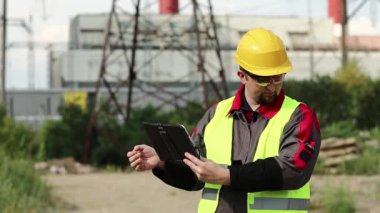 Elektrik santralinde kişisel bilgisayarda çalışan bir elektrik mühendisi. Isı elektrik santralinde çalışan, tablet bilgisayarlı, taşınabilir radyo vericisiyle konuşan bir işçi.