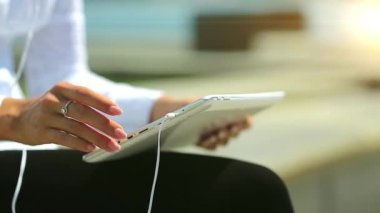 Kadın tablet bilgisayar kullanıyor, yakın plan. Fransız manikürlü kadın elleri tablet bilgisayarı tutuyor.