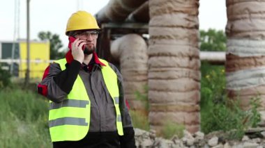 Servis mühendisi akıllı telefondan konuşuyor. İşçi, ana ısıtma hattının yakınındaki ısı elektrik santralinde cep telefonuyla konuşuyor. Sarı başlıklı ana mimar cep telefonuyla iletişim kuruyor