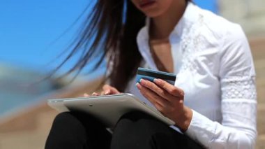 Kadın kredi kartıyla tablet bilgisayarla alışveriş yapıyor. Tablet bilgisayarda kredi kartıyla alışveriş yapmak. Fransız manikürlü kadın eller tableti tutuyor.