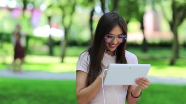 Güzel bir kadın tablet bilgisayar kullanır. Çekici kız beyaz tablet tableti elinde tutuyor.