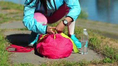 Kadınlar fiziksel egzersizden sonra eşyalarını kırmızı bir spor çantasına koyar. Kız spora gider, kız spor yapar.