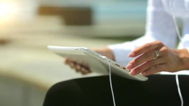 Kadın tablet bilgisayar kullanıyor, yakın plan. Fransız manikürlü kadın elleri tablet bilgisayarı tutuyor.