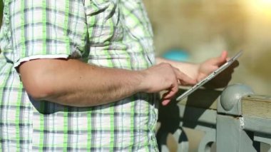 İşadamı tablet bilgisayarla çalışıyor. Adam tablet bilgisayar kullanıyor, tabletini elinde tutuyor.