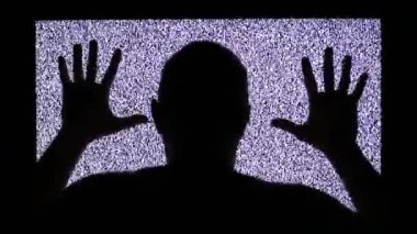 TV kanalı gürültüsü ve televizyon ekranındaki adamın siyah silueti. Adam televizyon ekranında grev yapıyor