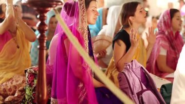 UKRAINE, KIEV, AĞUSTOS 4, 2017: Hindu geleneksel renkli kostümlü kadınlar Krishna tapınağında mantralar söylüyorlar