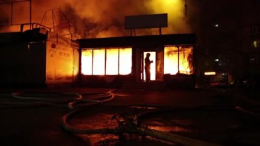 UKRAINE, KIEV, APRIL 5, 2017: Yanan binanın yakınındaki itfaiye ekibi. Ev yangınla yıkıldı. İçerideki cesur itfaiyeciler yangın söndürüyorlar.