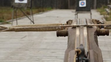 Tatar yayı bir hedefe nişan alınır. Eski ballista, eski ahşap arbalest ve arka plandaki hedefler