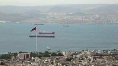 Ürdün 'deki Akabe şehri ve İsrail' deki Eilat şehri manzarası. Ürdün 'ün Akabe şehrindeki dağdan manzara. Bir video klipte iki şehir ve iki ülke