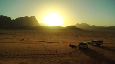 Wadi Rum Çölü 'nde arabalar, Ürdün Haşimi Krallığı. Wadi Rum, ayrıca Ay Vadisi olarak da bilinir, Ürdün 'ün en büyük ve pitoresk çölüdür. Wadi geleneksel olarak vadiden bahseden bir terimdir.
