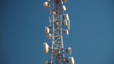 Cep telefonu telekomünikasyon kulesi. Mavi arka planda iletişim kulesi anteni. Cep telefonu iletişimi, televizyon, internet, radyo antenleri mavi gökyüzü arka planında