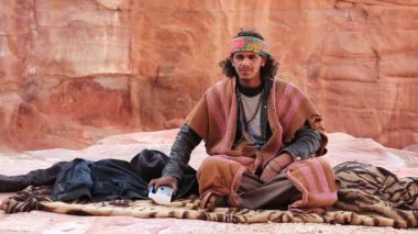 JORDAN, PETRA, 5 ARALIK 2016: Ürdünlü kameraya bakın, antik Petra, aslında Nabatealılar tarafından Raqmu olarak bilinir - Ürdün Haşim Krallığı 'nın tarihi ve arkeolojik kenti