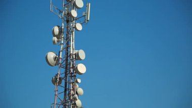 Cep telefonu telekomünikasyon kulesi. Mavi arka planda iletişim kulesi anteni. Cep telefonu iletişimi, televizyon, internet, radyo antenleri mavi gökyüzü arka planında