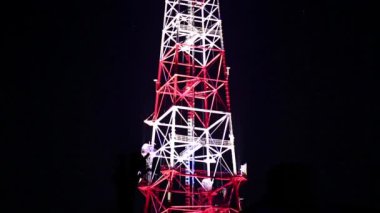 Cep telefonu iletişimi, televizyon, internet, radyo antenleri. Geceleri telekomünikasyon kulesi. İletişim kulesi anteninde siyah arkaplan üzerine aydınlatma