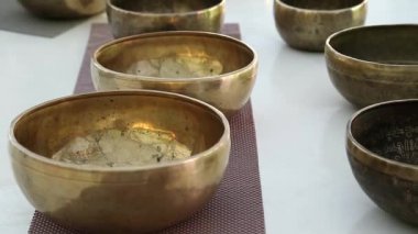 Meditasyon salonunda bronz Tibet şarkı kaseleri. Sarı Tibet kâseleri