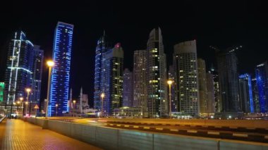 4K Dubai Limanı gece vardiyası, Birleşik Arap Emirlikleri. Dubai Marina, dünyanın en büyük insan yapımı marinası. Dubai Marina, Basra Körfezi 'nin 3 km' lik bir kıyı şeridi boyunca oyulmuş bir kanal kentidir.