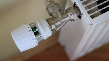 Adam akünün sıcaklığını ayarlıyor. Isı regülatörlü ısıtma pili. Isı kontrollü merkezi ısıtıcı. Ev ısıtma sistemi
