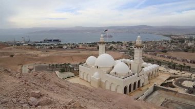Akabe şehri ve Ürdün Haşim Krallığı 'ndaki Akabe körfezi ve İsrail' in Eilat kenti uzak mesafede. Ürdün 'ün Akabe şehrindeki dağdan görünüşü. Bir video klipte iki şehir ve iki ülke