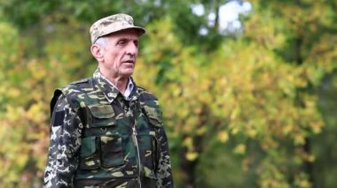 Yaşlı adam ormanda iki tabanca ateşler. Askeri üniformalı bir asker iki havalı tabancayla ateş eder. Askeri üniformalı bir asker tabancayla ateş ediyor. Poligondaki emekli memur.