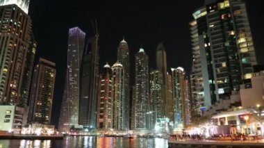 UHD 4K Dubai Marina gece yakınlaştırması, Birleşik Arap Emirlikleri. Dubai Marina, dünyanın en büyük insan yapımı marinası. Dubai Marina, Basra Körfezi 'nin 3 km' lik bir kıyı şeridi boyunca oyulmuş bir kanal kentidir.