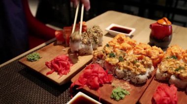 Adam restoranda masada oturur ve Japon yemeği yer. Adam Japon restoranında suşi yiyor.