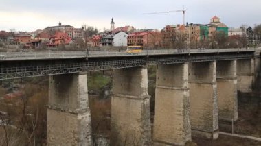 Kamianets-Podilskyi şehrindeki Novoplanovskiy Köprüsü, Ukrayna 'nın batısındaki tarihi Podolia bölgesinde yer alıyor. Araçlar ve insanlar Smotrych nehri üzerindeki taş köprüde, Kamianets-Podilskyi şehri, uzunluğu 136 metre.
