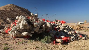 Ürdün 'ün Akabe kenti yakınlarındaki çölde inşaat atığı bulunuyor. Arka planda endüstriyel fabrika. İnşa etmek doğada yatar.