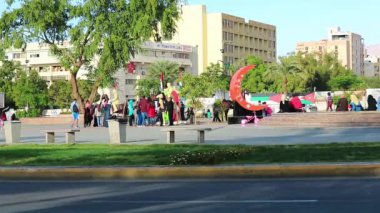 JORDAN, AQABA, 16 ARALIK 2016: Ürdün 'ün Akabe kentindeki Ayla Meydanı' ndaki Büyük Arap İsyanı 'nın 100. yıldönümü anıtının yakınındaki karayolu trafiği ve insanlar, resmi adıyla Ürdün Haşimi Krallığı