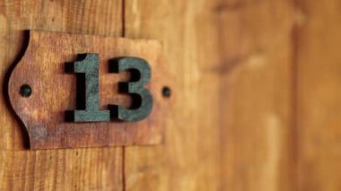 On üç numaralı otel odası. 13 numaralı odanın tahta kapısı. Ev plakası on üç, fırıncılar düzinesi, yedinci Fibonacci numarası yakın plan. Triskaidekaphobia - On üç numaranın batıl korkusu