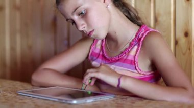 Kız masada oturuyor ve tablet bilgisayar kullanıyor. Güzel kız tablet kullanıyor. Tablet pc ile kadın