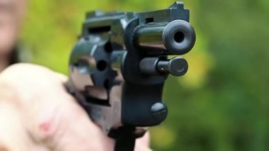 Adam elinde siyah bir tabanca tutuyor. Poligondaki emekli memur. Yaşlı adam ormanda tabanca ateşler. Siyah silahlı adam, yaklaşın.