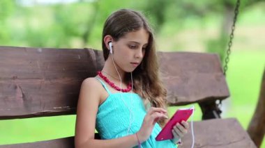 Mavi elbiseli kız oyunu onun akıllı telefonuyla oynuyor. Akıllı telefonlu bir kadın. Güzel kız salıncakta oturuyor ve kırmızı akıllı telefon kullanıyor. Akıllı telefonlu çekici bir kız bankta oturuyor.