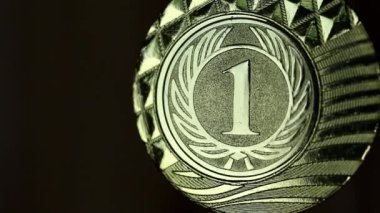Birincilik madalyası. Altın madalya, kazanana verilir. Siyah arka planda yarışma kazanana madalya. Birincilik madalyası